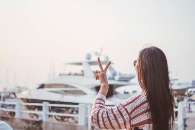 Woman standing by boat against sky