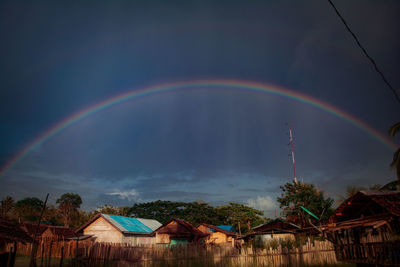 Rainbow over buildings against sky