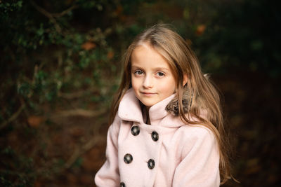 Portrait of girl standing against plants