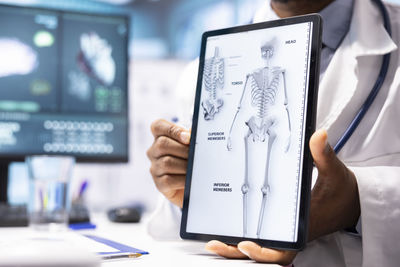 Midsection of man using digital tablet in office