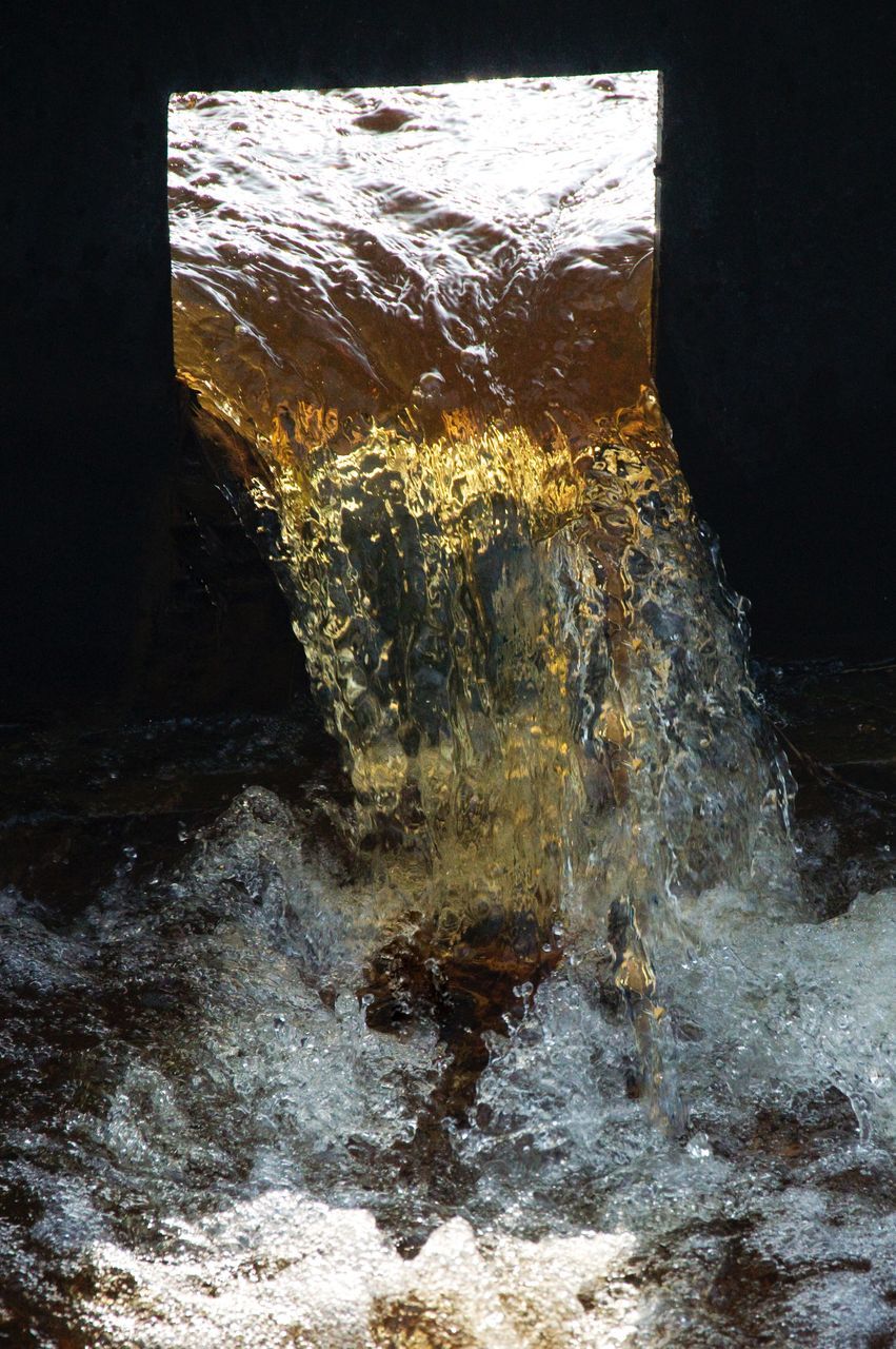CLOSE-UP OF WATER FLOWING ON ROCKS