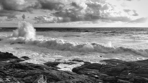 Waves splashing on sea against sky