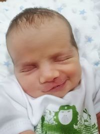 Portrait of cute baby girl lying on bed