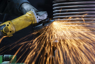 Close-up of worker using angle grinder in a factory