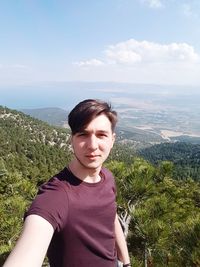 Portrait of young man against mountain range