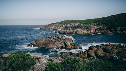 Scenic view of rocks on beach against sky