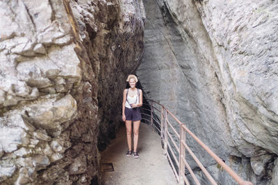 Woman standing on bridge in cave
