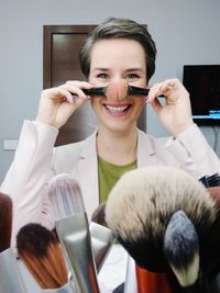 Portrait of smiling woman holding make-up brush