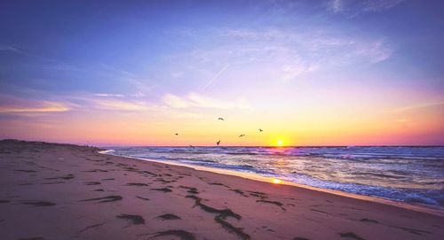 Scenic view of beach against sky during sunset