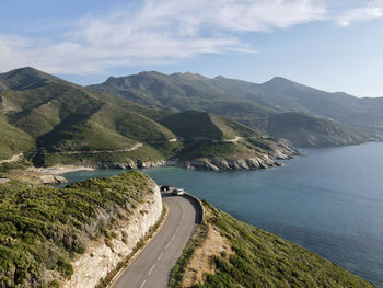 Scenic view of road by mountains against sky