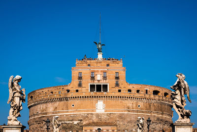 Low angle view of statue against blue sky