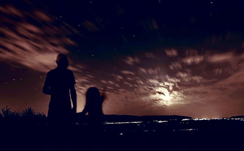 Silhouette people looking at view of sky during sunset