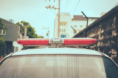 Close-up of car against buildings in city