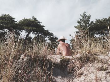 Woman standing on tree trunk