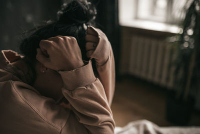 Rear view of woman sitting at home