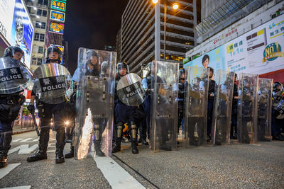 People standing on city street at night