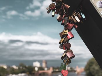 Close-up of padlocks on railing against sky