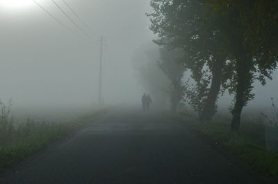 Man walking on road in foggy weather