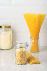 Gluten free pasta in a glass jar on the table. pasta made from corn and rice flour for diet food.