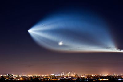 Light over illuminated cityscape at night