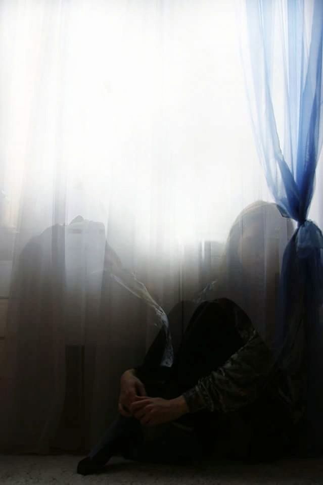 curtain, one person, indoors, sitting, window, sadness, real people, lifestyles, full length, adult, day, women, home interior, emotion, bed, depression - sadness, relaxation, domestic room, furniture, depression