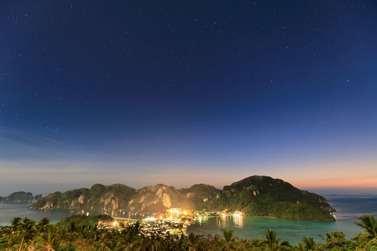 SCENIC VIEW OF SEA AND MOUNTAINS AGAINST BLUE SKY