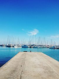 Sailboats in sea against clear blue sky
