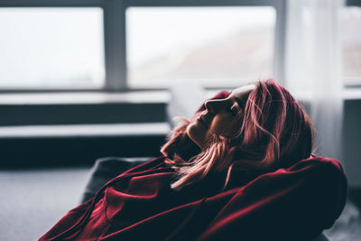 Rear view of woman looking through window