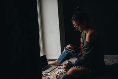 Woman using mobile phone while siting at home