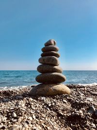 Stack of stones on beach against sky