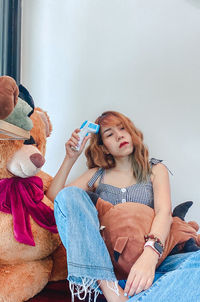 Young woman sitting on wall at home