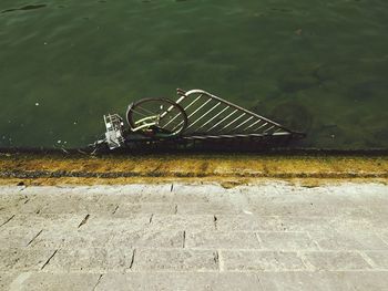 High angle view of bicycle on wall by lake