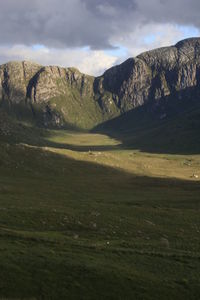 Scenic view of field and mountains against sky