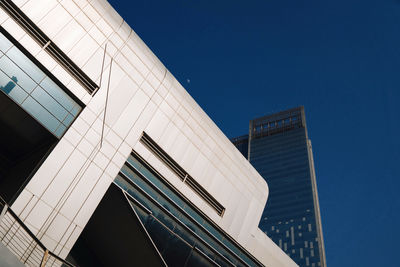 Low angle view of modern buildings against clear blue sky