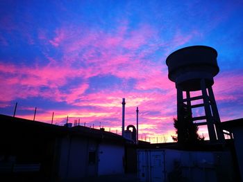 Low angle view of water tower against sky during sunset