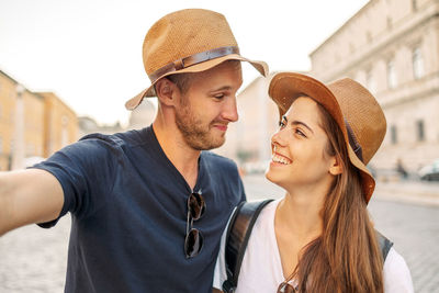 Side view of young woman wearing hat standing outdoors