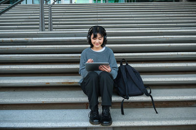 Portrait of young woman sitting on steps