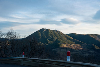 Road by mountains against sky