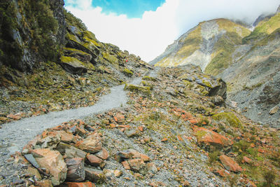 Scenic view of river flowing amidst mountains against sky