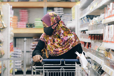 Woman wearing mask and shopping in store