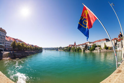 View of flags over river with buildings in background