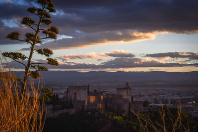 Scenic view of sea and cityscape against sky at sunset