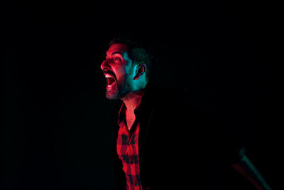 Portrait of young man against black background