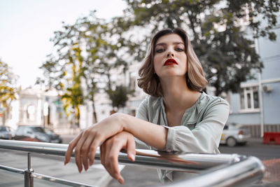 Portrait of beautiful young woman against trees