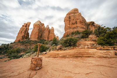 Cathedral rock spires with trail marker and clouds in sky sedona arizona