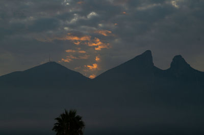 Scenic view of silhouette mountains against sky at sunset