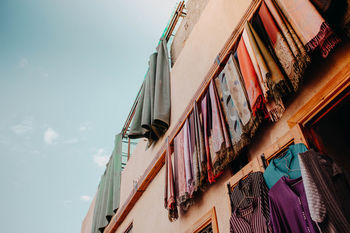 LOW ANGLE VIEW OF CLOTHES HANGING ON BUILDING