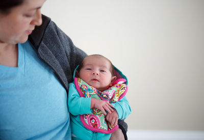 Woman mother holding newborn baby in hospital after pregnancy labor and delivery in maternity ward