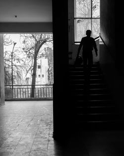 Rear view of silhouette man walking in building