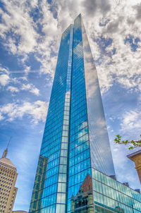 Low angle view of modern building against cloudy sky